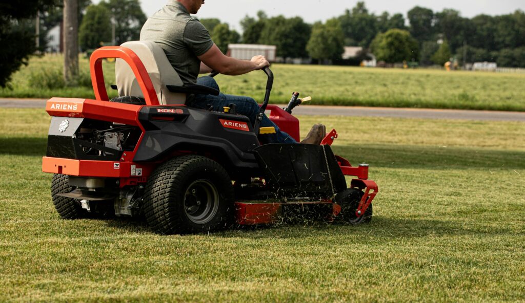 Yard Boys crew member mowing a lawn with a zero-turn mower